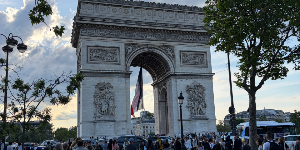 The Arc de Triomphe in Paris at sunset, viewed from street level